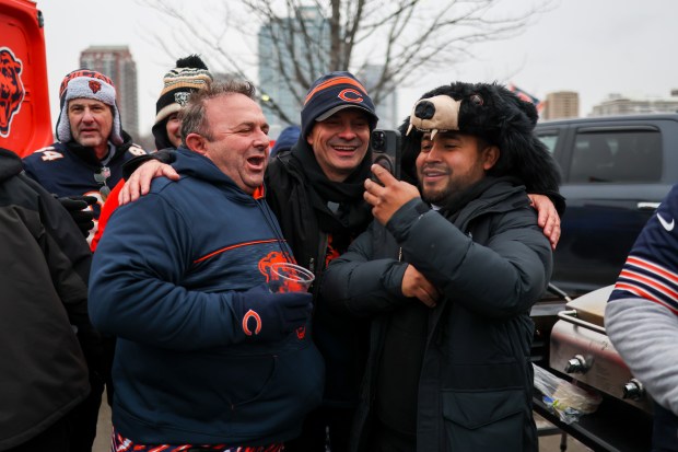 Ridvan Alka, left, laughs as he tailgates outside with friends outside of Soldier Field before the Chicago Bears play the Los Angeles Rams in the NFC divisional playoff game on Jan. 18, 2026. (Eileen T. Meslar/Chicago Tribune)