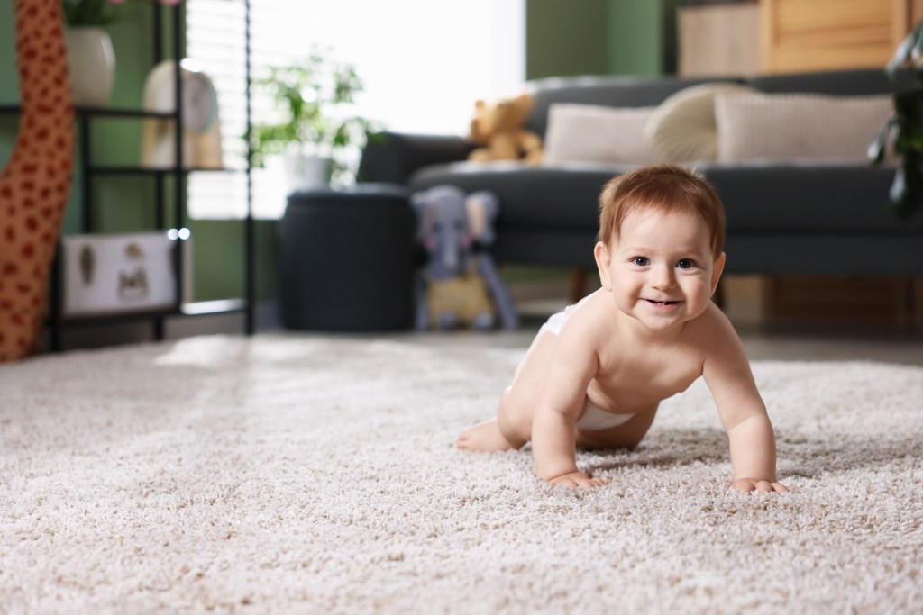Happy baby crawling on a shag carpet.