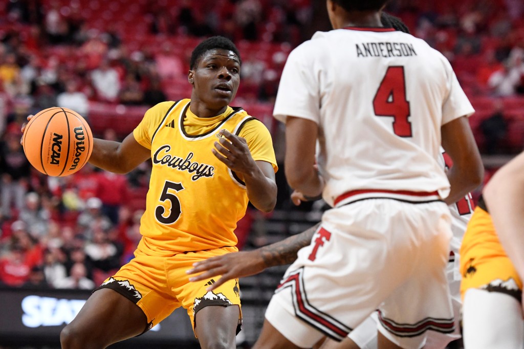 Wyoming guard Leland Walker (5) dribbles the ball during the second half in an NCAA college basketball game against Texas Tech.