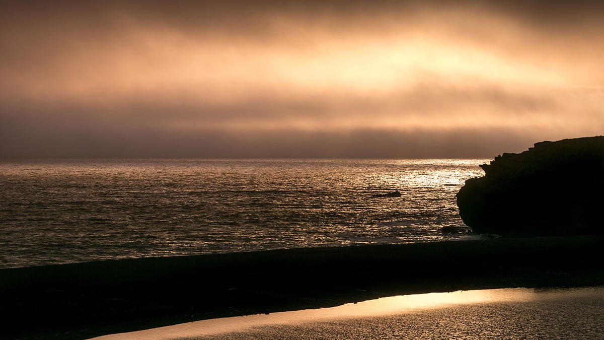 Sun sets over beach in Gualala, California
