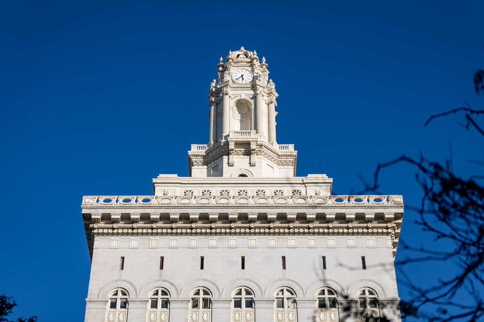 The top floors and spire of Oakland City Hall on a day with clear blue skies.