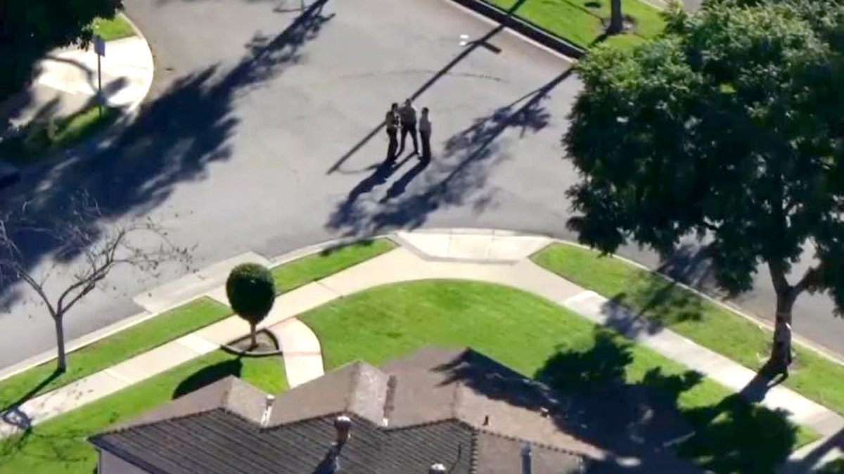deputies standing in street outside home