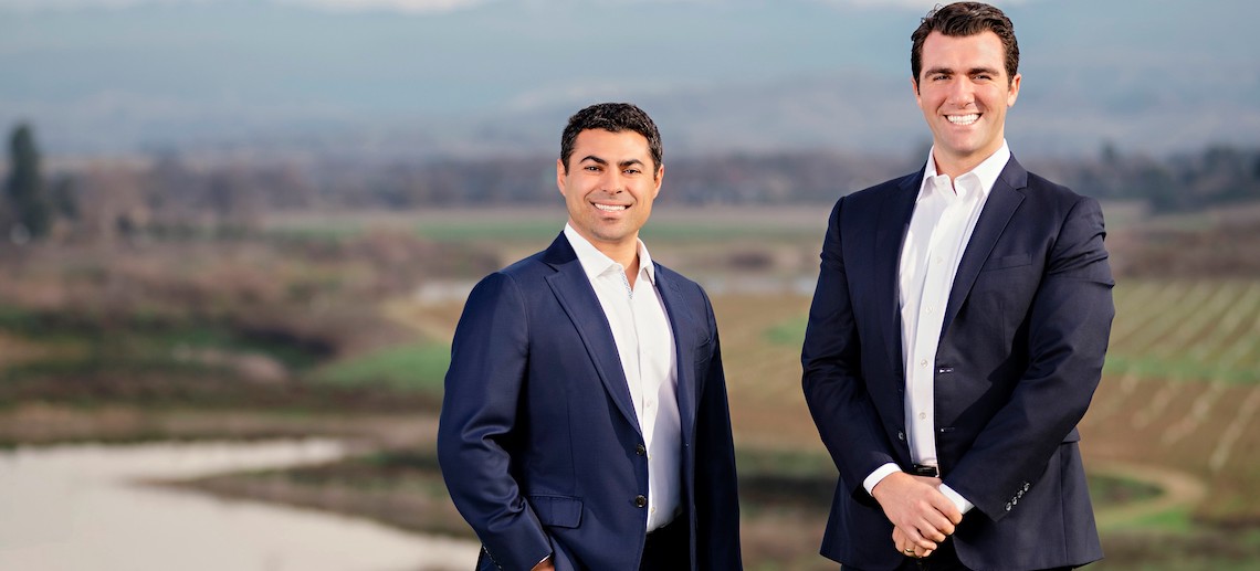 two men in front of a river vista
