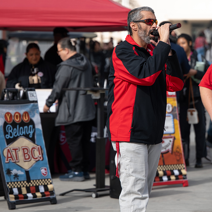 Dr. Damania talking into a microphone addressing attendees