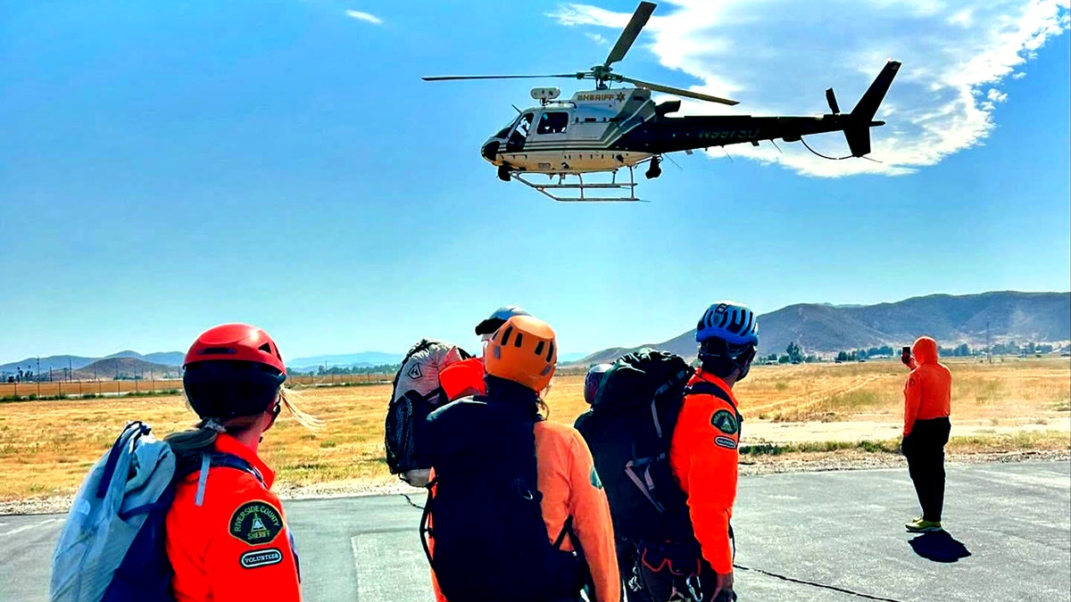 Riverside Mountain Rescue Unit members looking up at helicopter