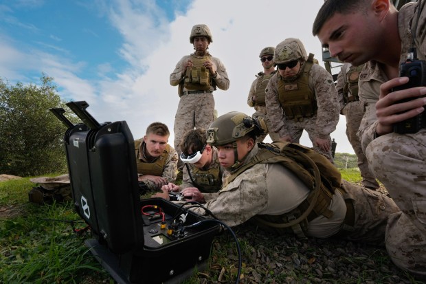 At a live fire range on Camp Pendleton, Marines operate the drone to reach a target located approximately a mile from their position.   (Nelvin C. Cepeda / The San Diego Union-Tribune)