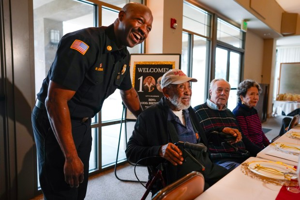 San Diego Fire Department Fire Chief Robert Logan chatted with Alwin Benjamin Holman while at his 100th birthday party held at the Faith Presbyterian Church on Friday, Dec. 26, 2025, in San Diego, CA. Holman, born on December 26th, 1925, was hired as a probationary firefighter in 1951.  On that day he reported to work, which also marked the end of segregation at the San Diego Fire Department. Holman was promoted to battalion chief and later to deputy chief, becoming the first Black individual in California to achieve the rank of deputy chief. He eventually retired in 1983 after thirty-two years of service. (Nelvin C. Cepeda / The San Diego Union-Tribune)