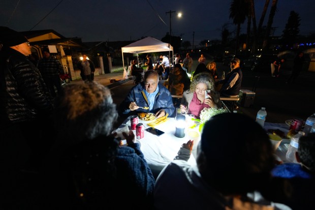 On Thursday, Jan. 22, 2026 in San Diego, flood survivors, Carlos Ramirez and his daughter, Maria Martinez of Southcrest, enjoyed a dinner meal during the block party. (Nelvin C. Cepeda / The San Diego Union-Tribune)
