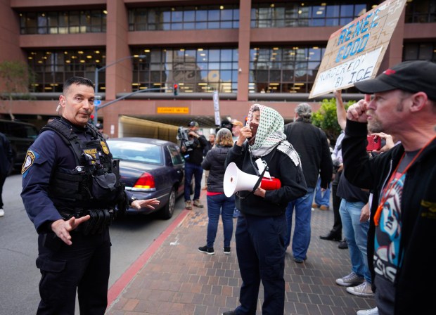 Demonstrators confronted federal agents when they detained and cited and drive for temporary parking on a red curb near the federal building before the protest Thursday morning. (Nelvin C. Cepeda / The San Diego Union-Tribune)