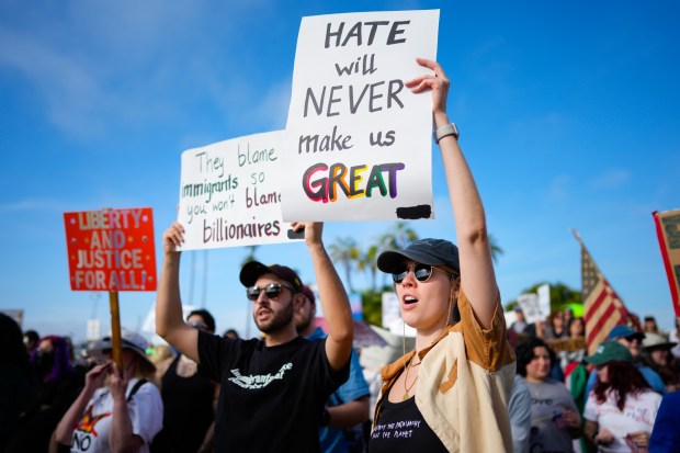Protesters hold up signs during the "Free America Walkout" in front of the San Diego County Administration Center on Tuesday. (Nelvin C. Cepeda / The San Diego Union-Tribune)