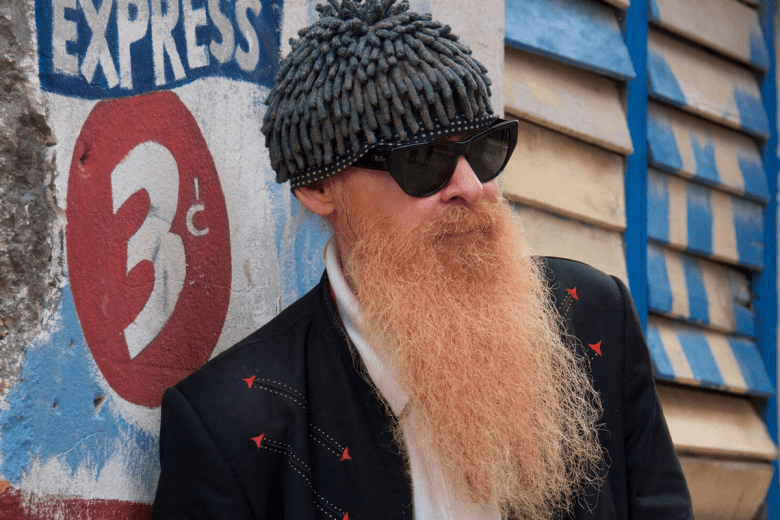 Close up of man with long beard wearing funky toque and sunglasses