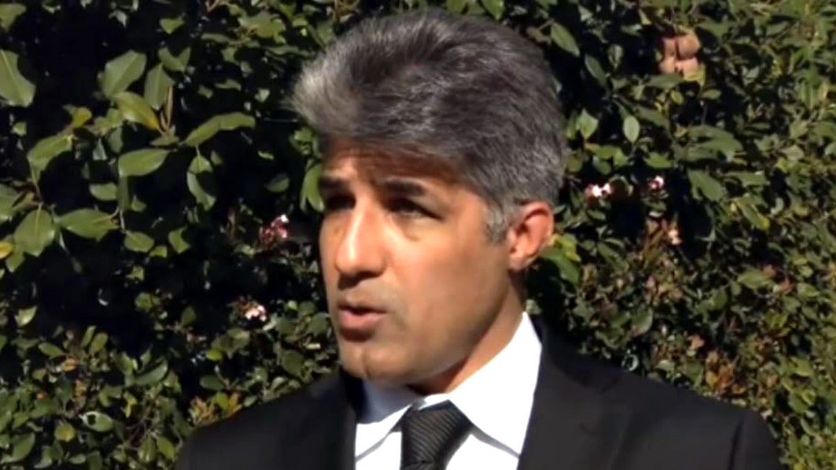 Calor Madanescht in black suit speaks during interview