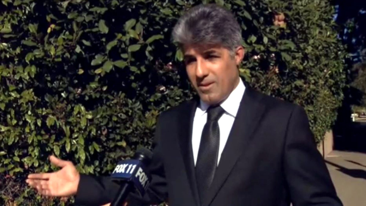 Calor Madanescht in black suit speaks during interview