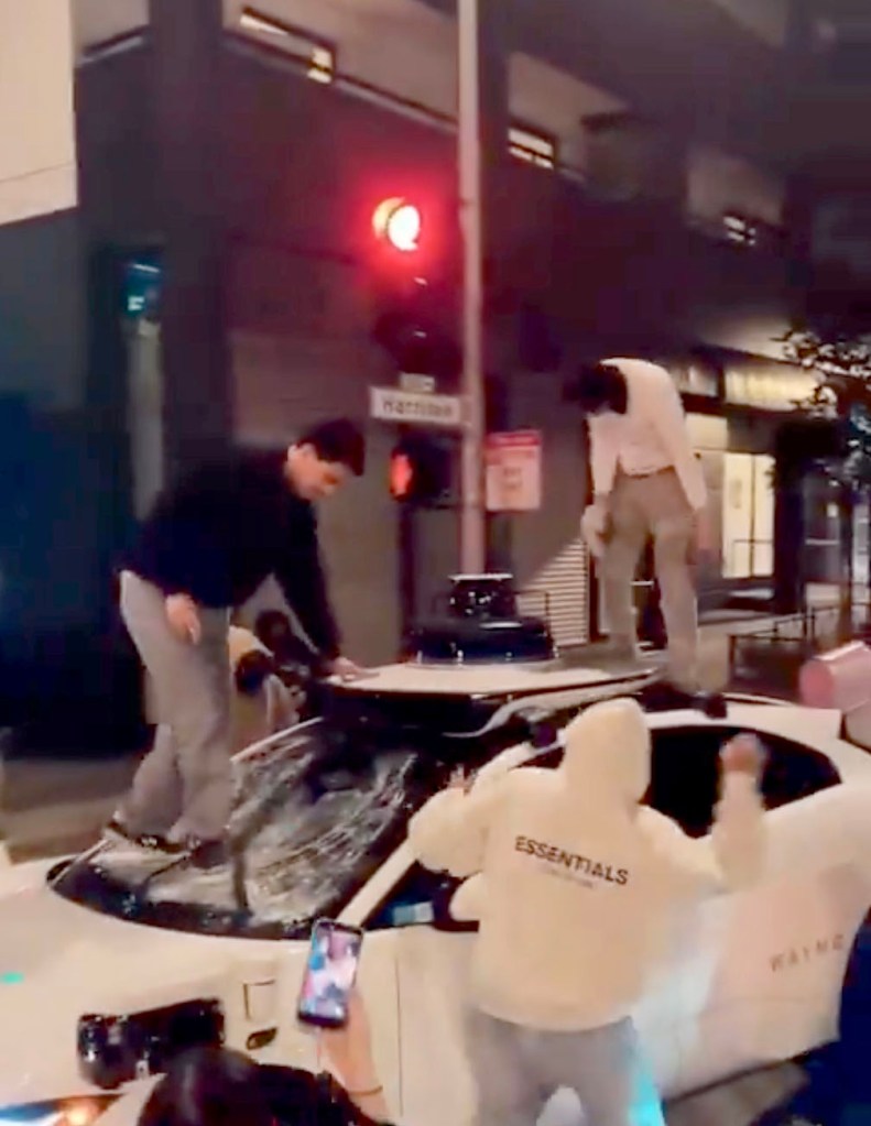 A mob destroying a Waymo self-driving car in San Francisco.