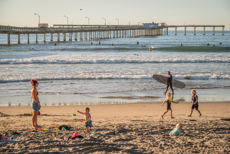 People enjoy the beach near the Ocean Beach Pier, which has been closed since 2023. (Photo by Vito Di Stefano/Special for Times of San Diego)