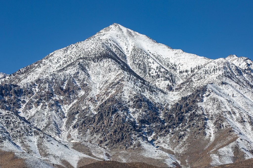 Snow-covered mountainside against a deep blue sky.