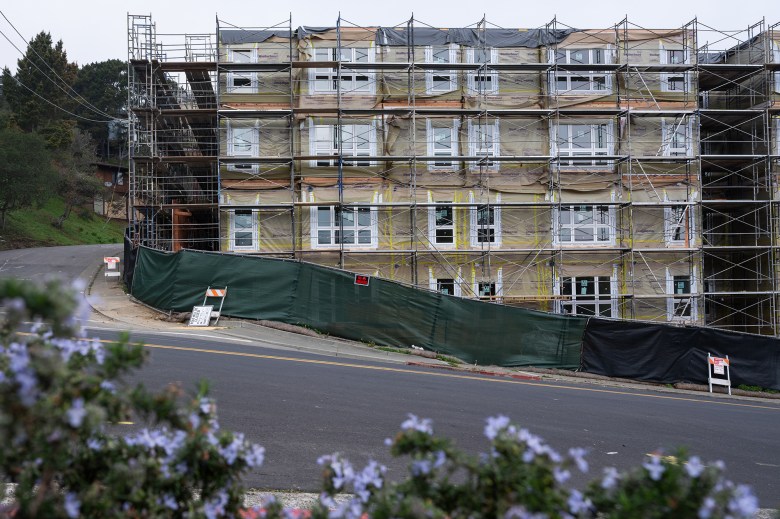 Scaffolding adorns the facade of an apartment complex under construction.
