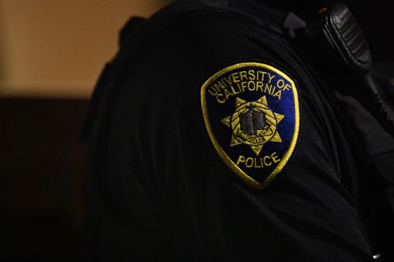 A blue and yellow patch with the seal of the University of California police is seen on an officer's uniform.