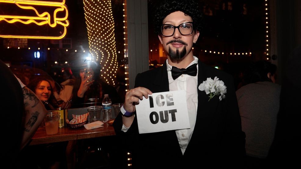 A contestant at the Bad Bunny look-alike contestholds an "ICE OUT" sign throughout the evening  at Tacolicious in San Francisco, Thursday, Feb. 5, 2026. (Giselle Garza Lerma/San Francisco Chronicle via AP)