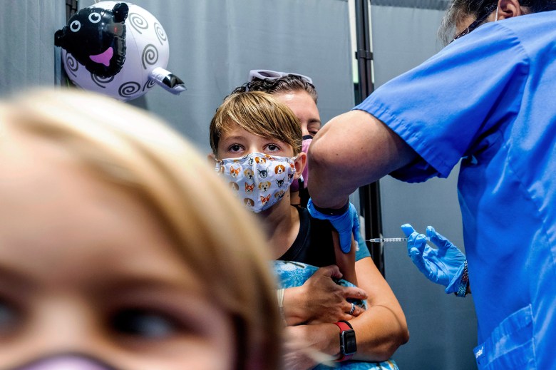 Finn Washburn, 9, receives the COVID-19 vaccine in San Jose as his sister, Piper Washburn, 6, waits her turn on on Nov. 3, 2021. Photo by Noah Berger, AP Photo