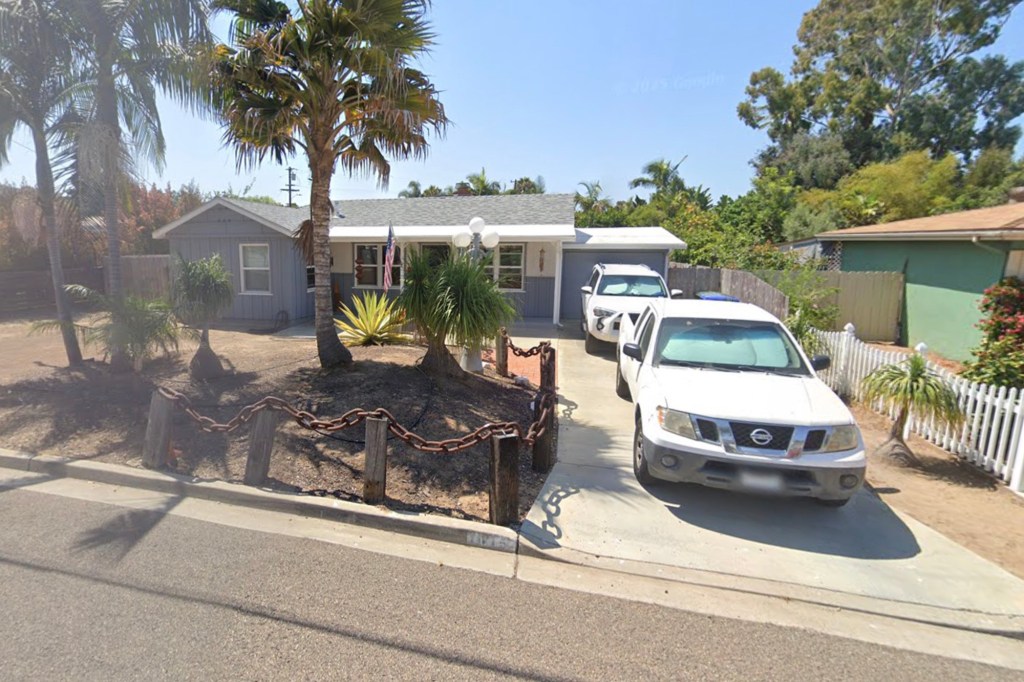 House at 1024 Laguna Drive #12 with palm trees and a chain-link fence in front.