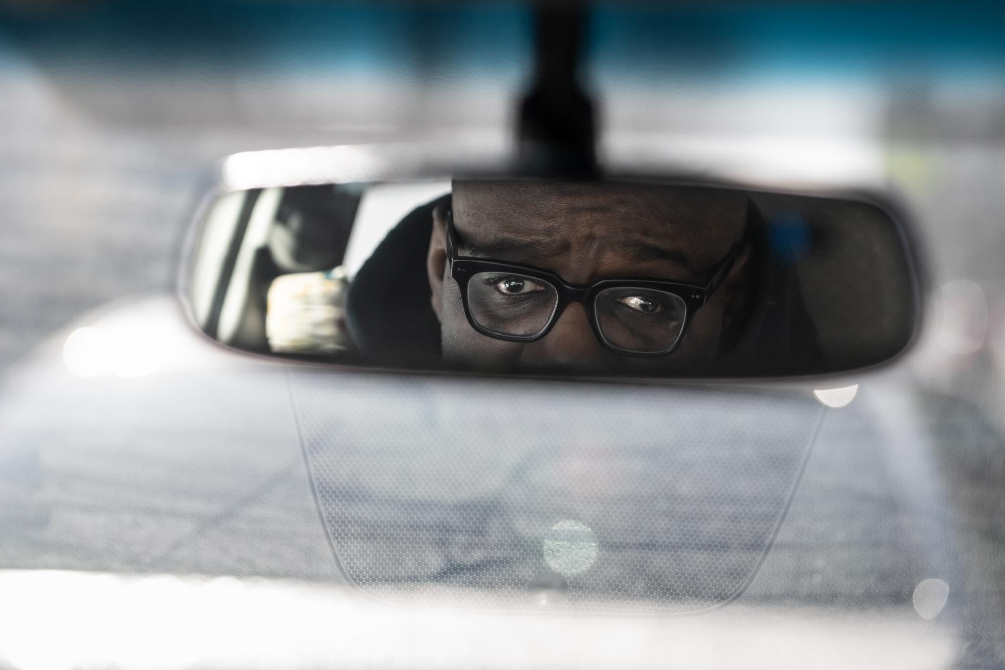 Civil rights attorney James  Cook in the rear view mirror as he makes phone calls in his car in Minneapolis.