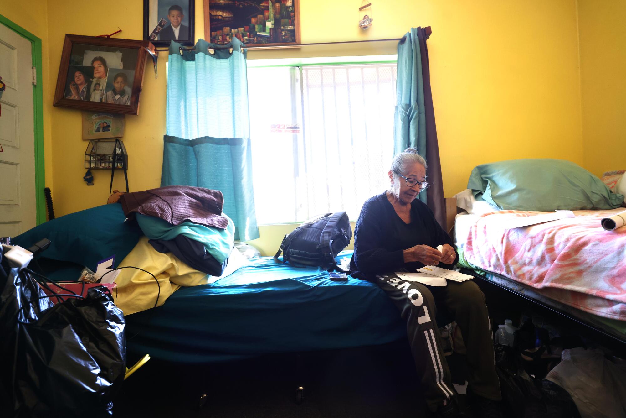 A woman sits on a bed.