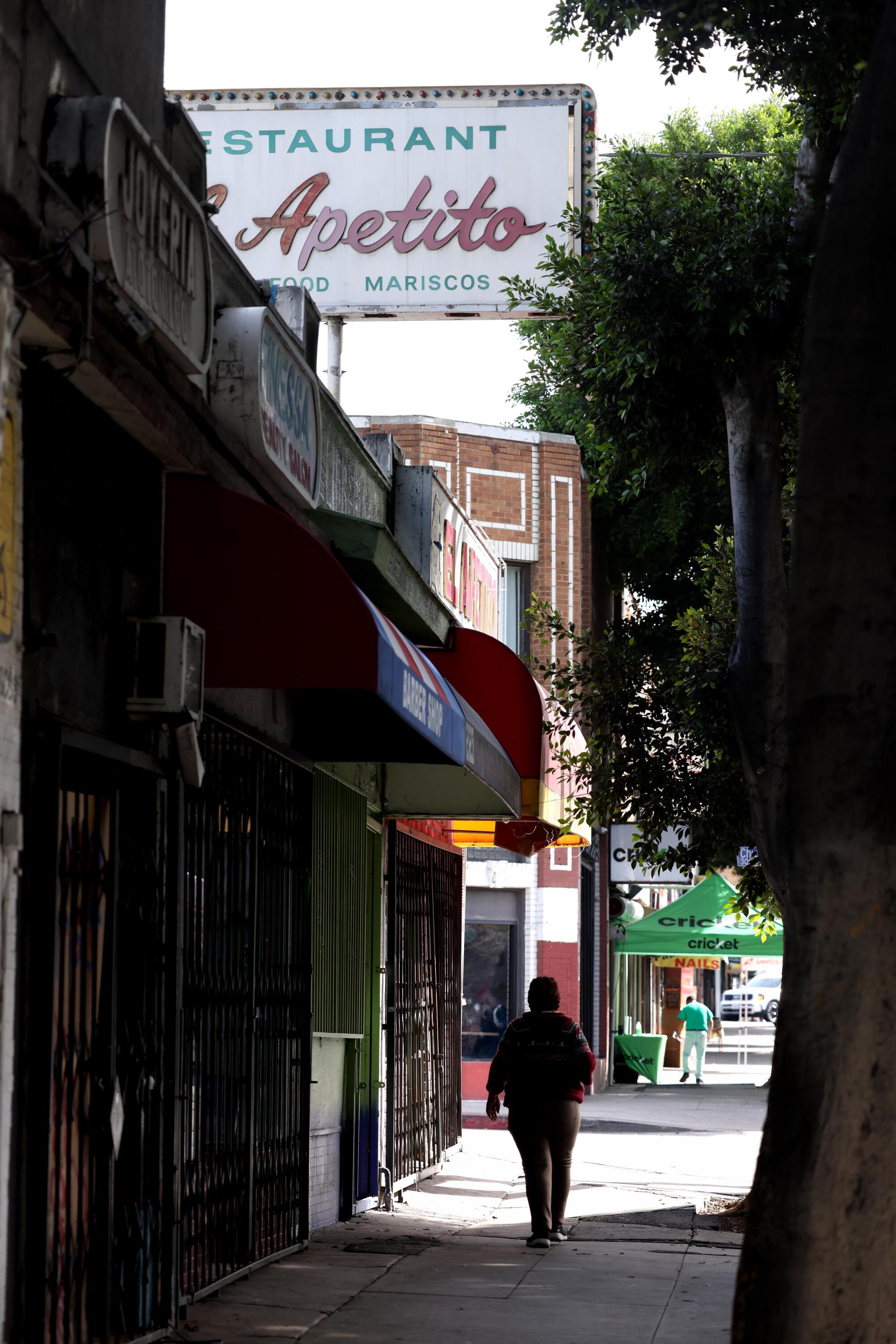 A person walks down a city sidewalk.