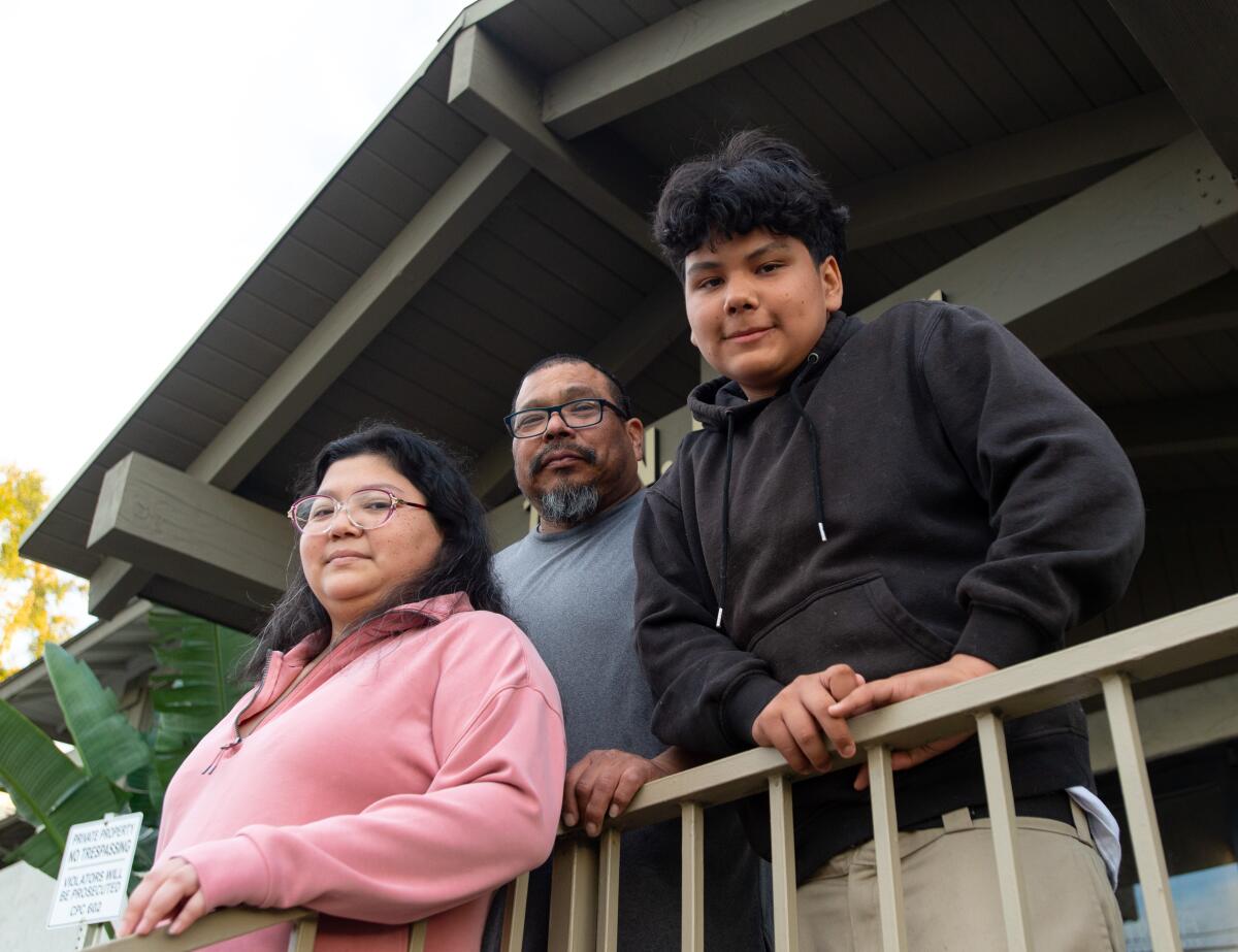 Marie Pineda, from left, Patricio Pineda and Daniel Pineda pose for a photo in front of their new apartment.