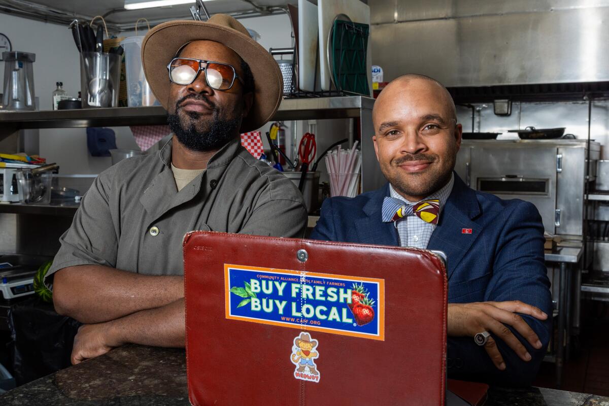 Chef Amin Muhammad, left and Adam X, right stand inside of the Crenshaw Food Hub. 