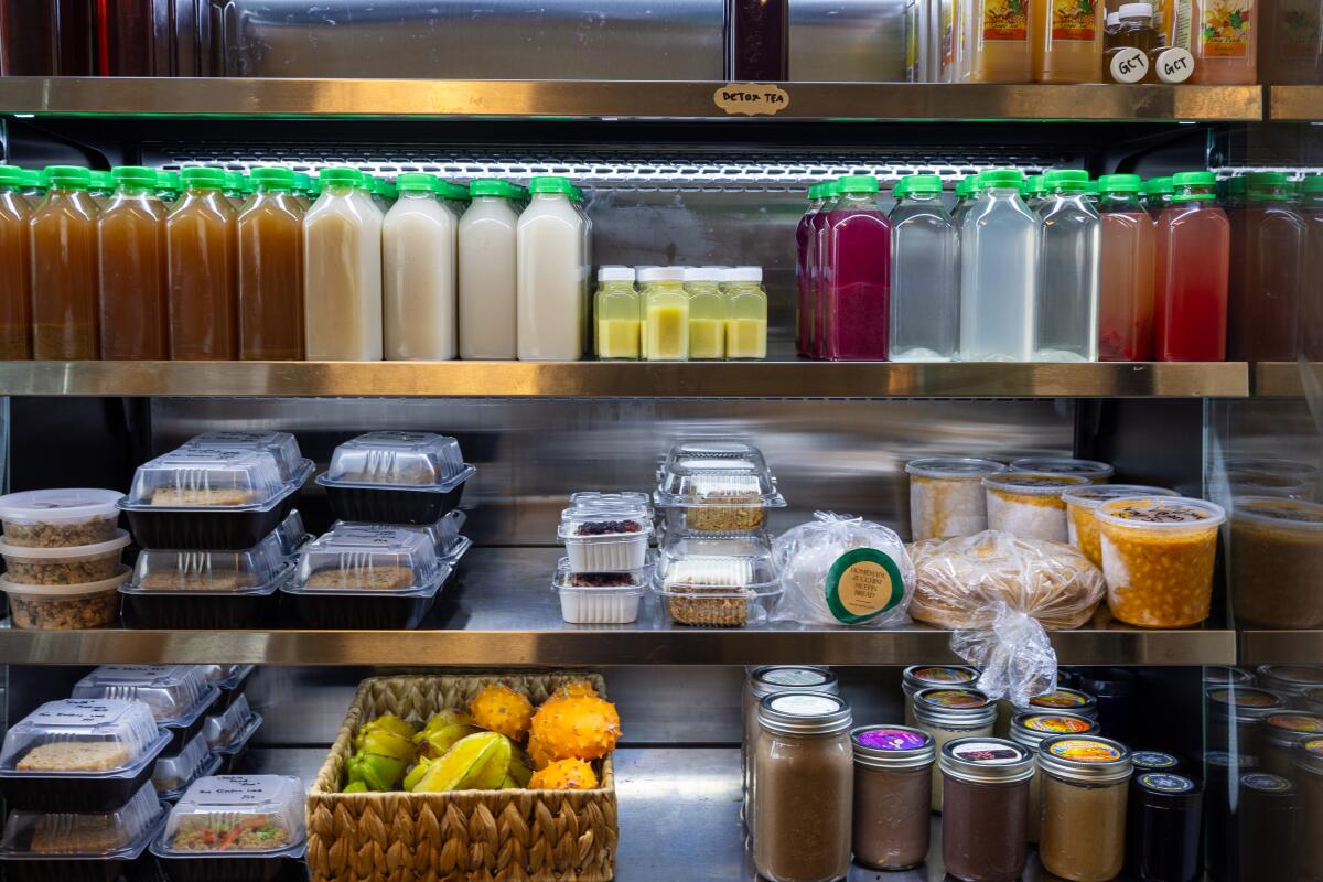 Pressed juices and other food items in a refrigerator for sale at the Crenshaw Food Hub. 