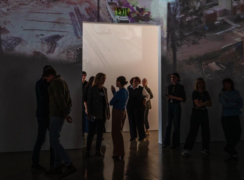 "Once in a Lifetime" is part video display and part sculpture, made of tripods, toothpicks, lights, cardboard boxes and projectors that flicker images on the gallery walls.