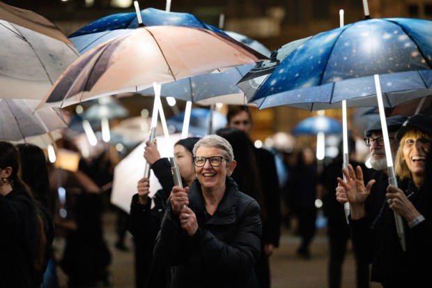 Participants march with umbrellas printed with aerial photographs at City Hall in San Jose, Calif., on Saturday, Jan. 31, 2026. (Thien-An Truong for Bay Area News Group)