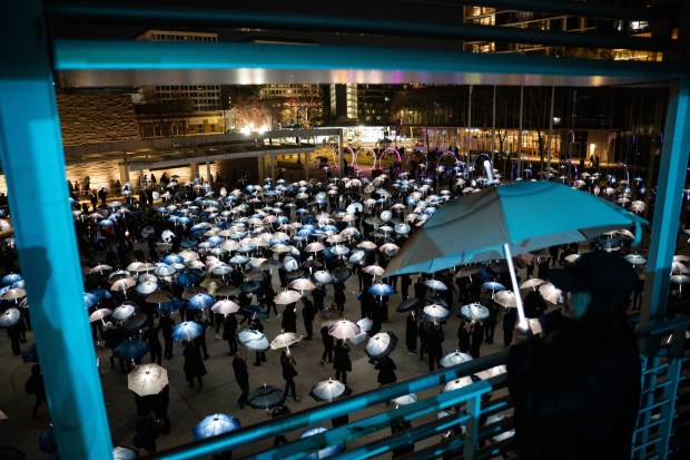 Participants march with umbrellas printed with aerial photographs at City Hall in San Jose, Calif., on Saturday, Jan. 31, 2026. (Thien-An Truong for Bay Area News Group)