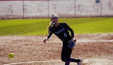 Hollie Farmer charging toward home plate from her third base position.
