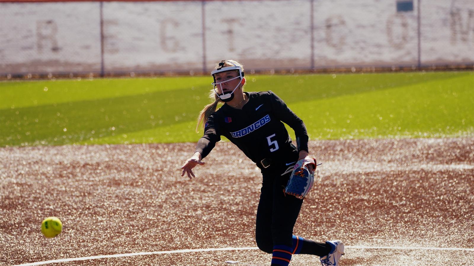 Hollie Farmer charging toward home plate from her third base position.