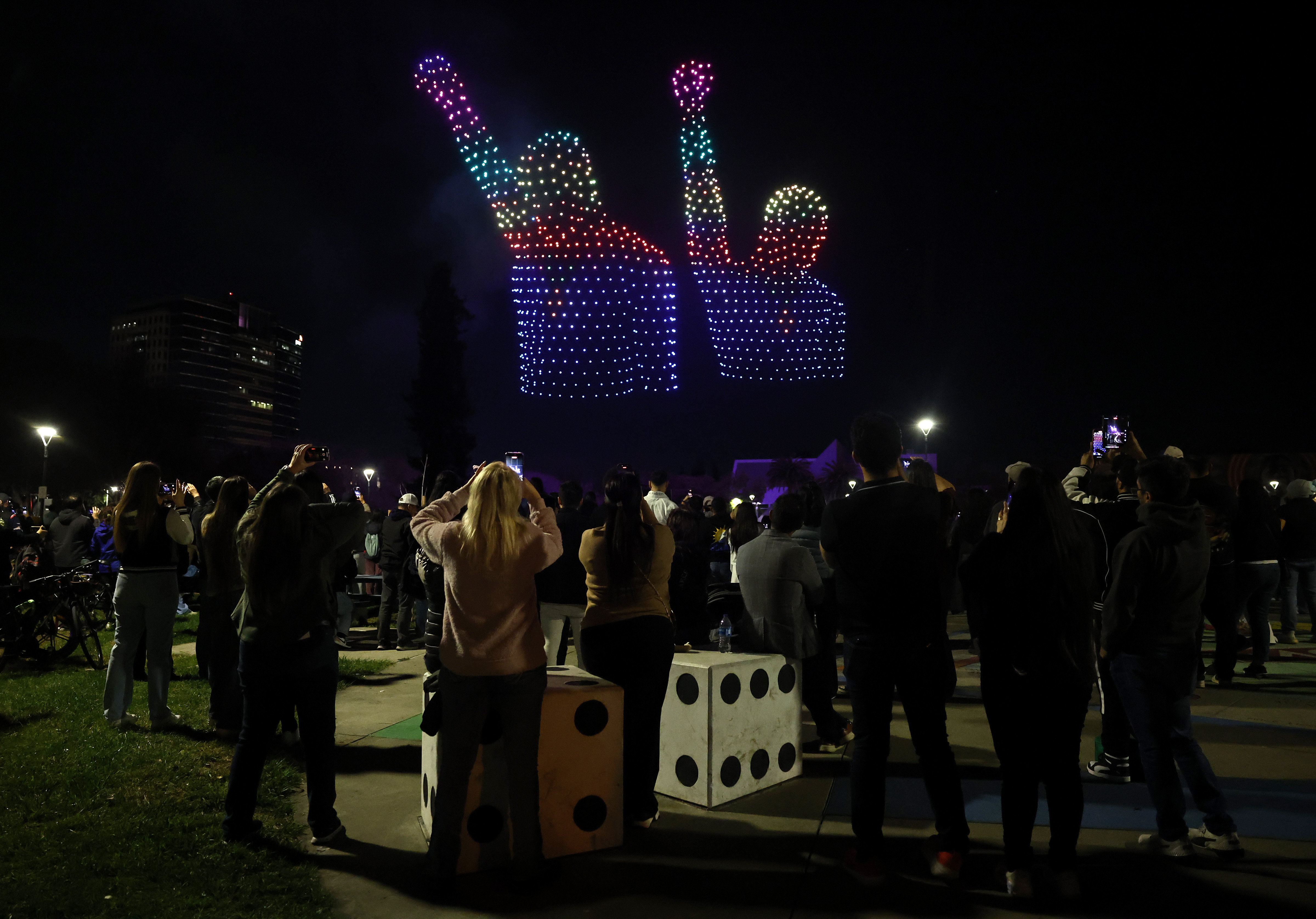 People watch a drone show which depicts San Jose State...
