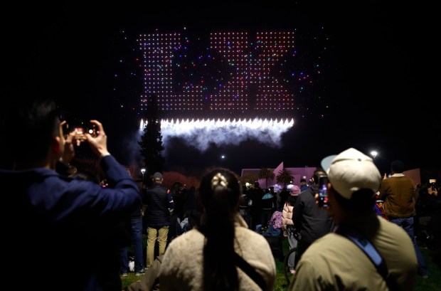 People watch a drone show which depicts the Super Bowl LX logo on Super Bowl Opening Night in Discovery Meadow in downtown San Jose, Calif., on Monday, Feb. 2, 2026. (Nhat V. Meyer/Bay Area News Group)