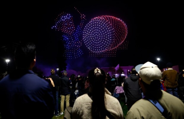 People watch a drone show which depicts a San Jose Taiko drummer in Discovery Meadow on Super Bowl Opening Night in downtown San Jose, Calif., on Monday, Feb. 2, 2026. (Nhat V. Meyer/Bay Area News Group)