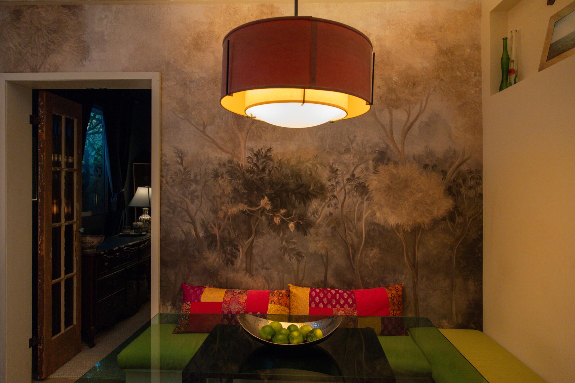 The dining table area in Adams' space is decorated with an enchanted forest-themed wallpaper.