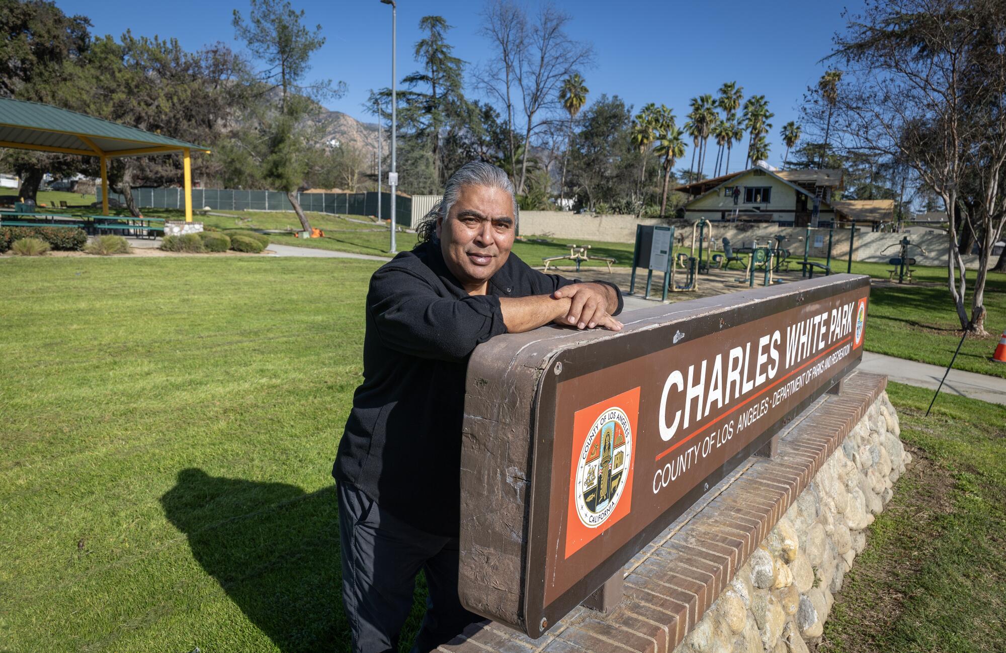 A man by a park sign.