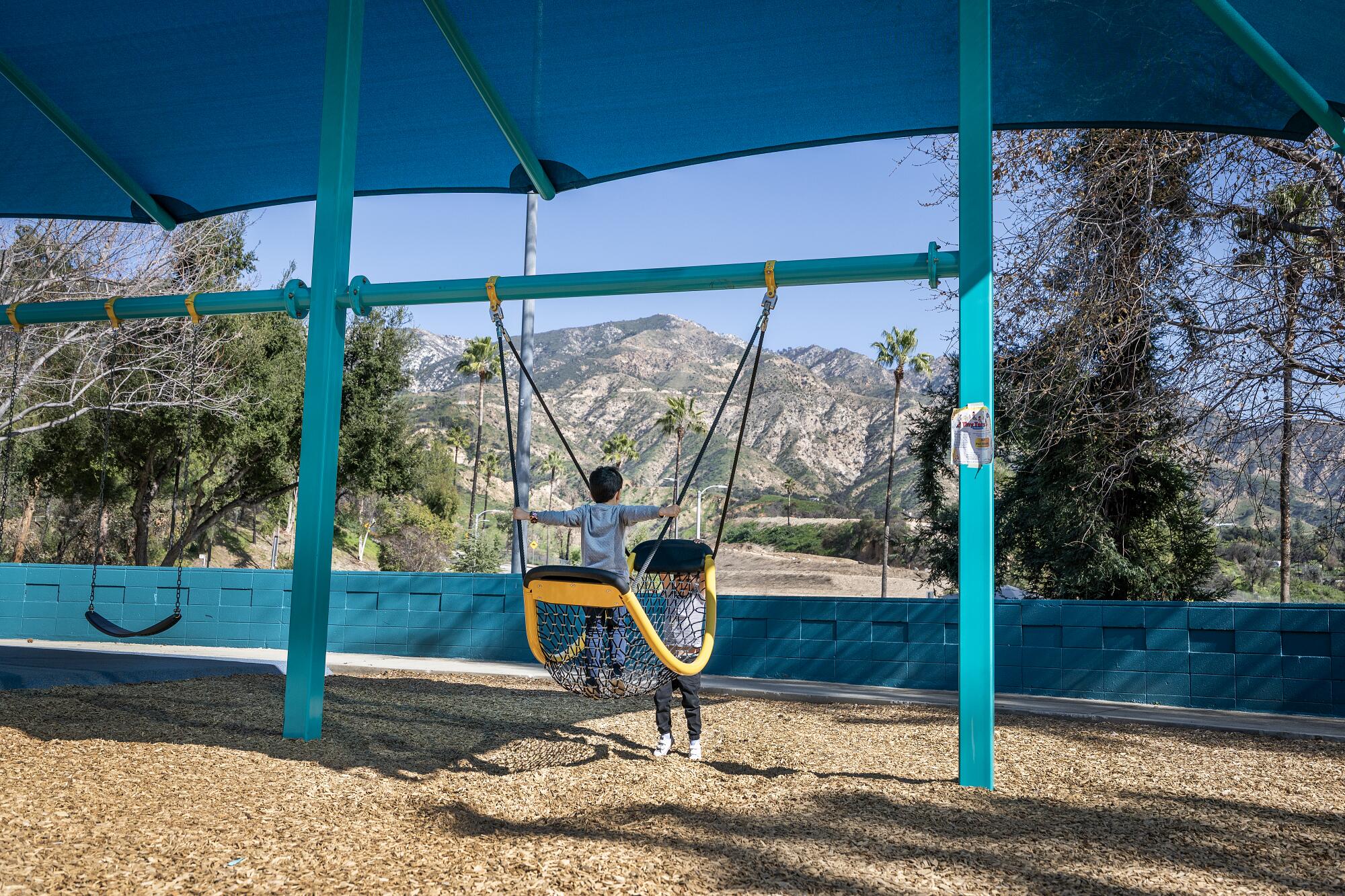 Children play on a swingset.