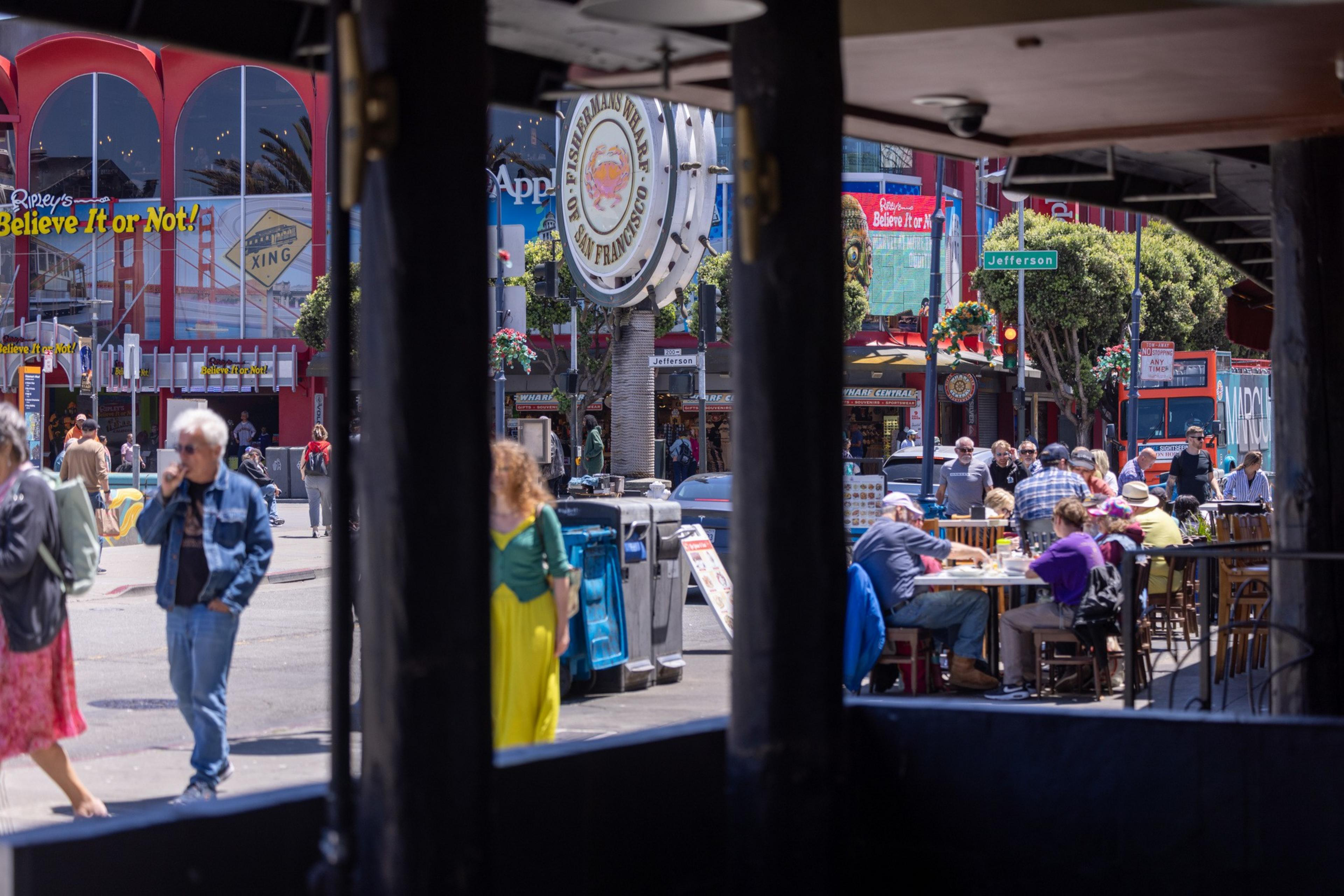 The image shows a bustling street scene with people walking and dining outdoors. There’s a prominent “Ripley’s Believe It or Not!” sign, and a large Fisherman’s Wharf sign.