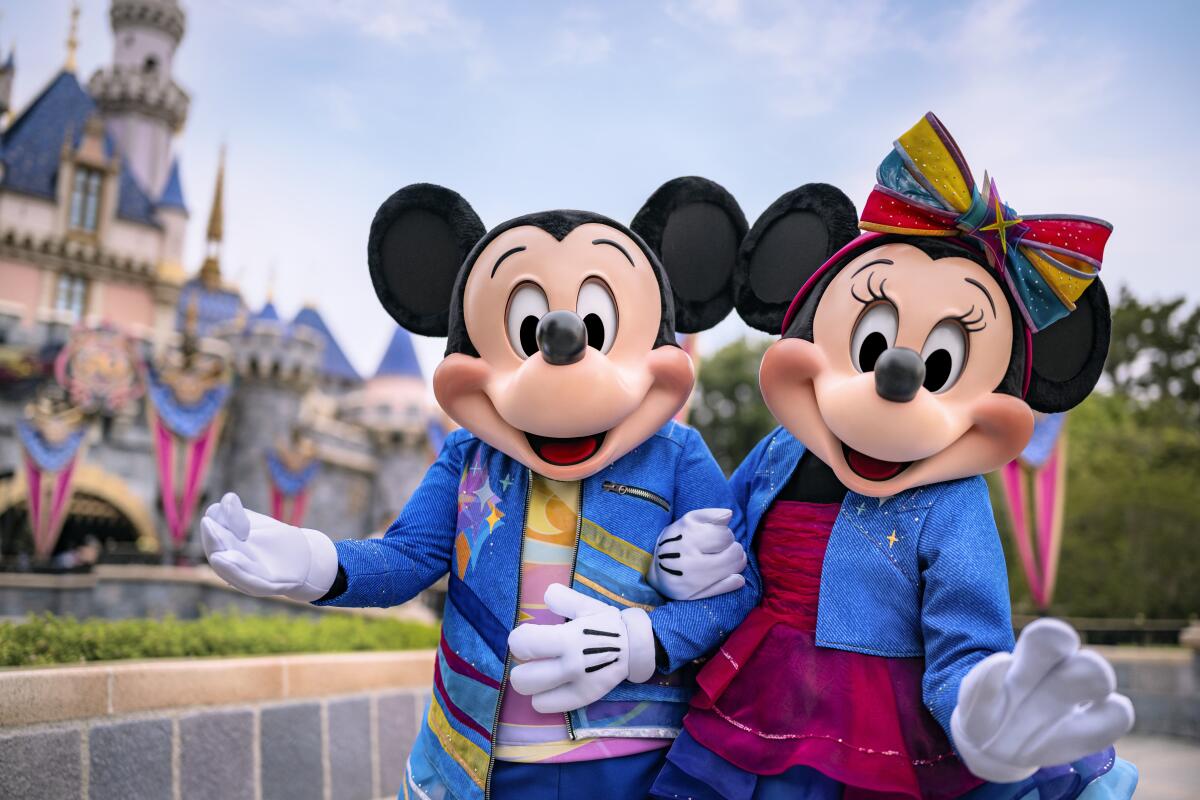 Mickey and Minnie mouse in front of Sleeping Beauty Castle. 