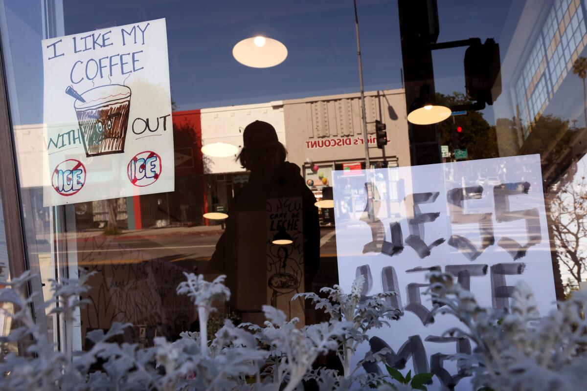 A sign reading "I like my coffee without ICE" is posted in the window of Cafe de Leche in Highland Park.