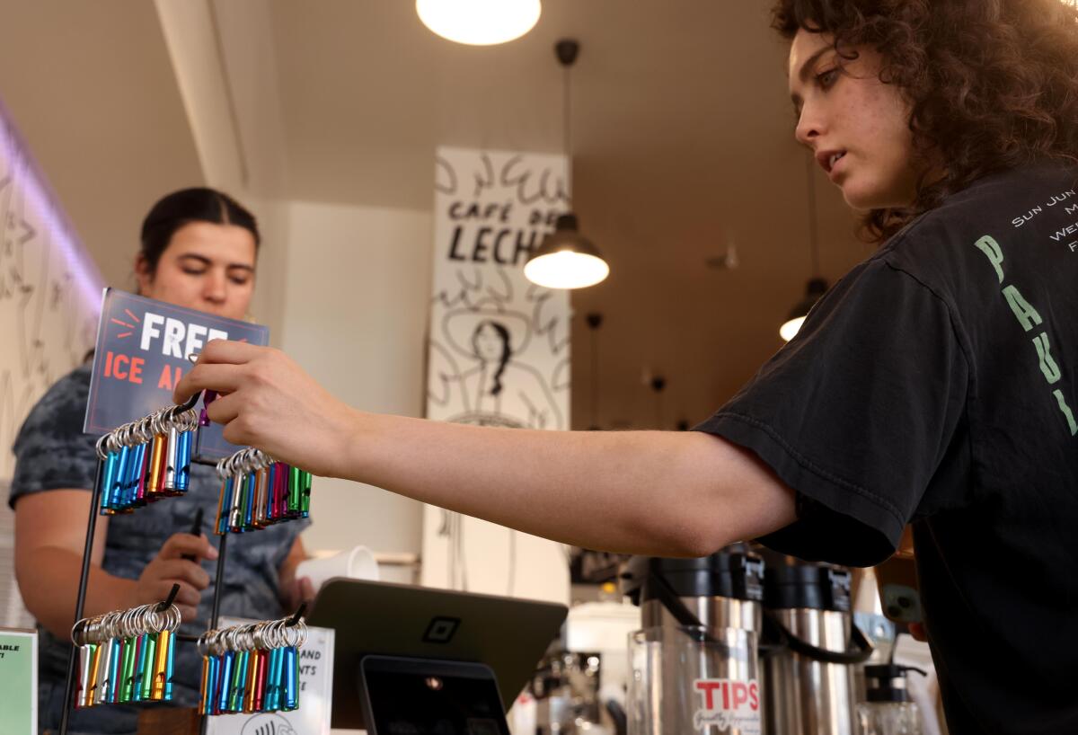 Hana McElroy, right, picks up a free whistle while ordering a cup of coffee from Soleil Hernando at Cafe de Leche.