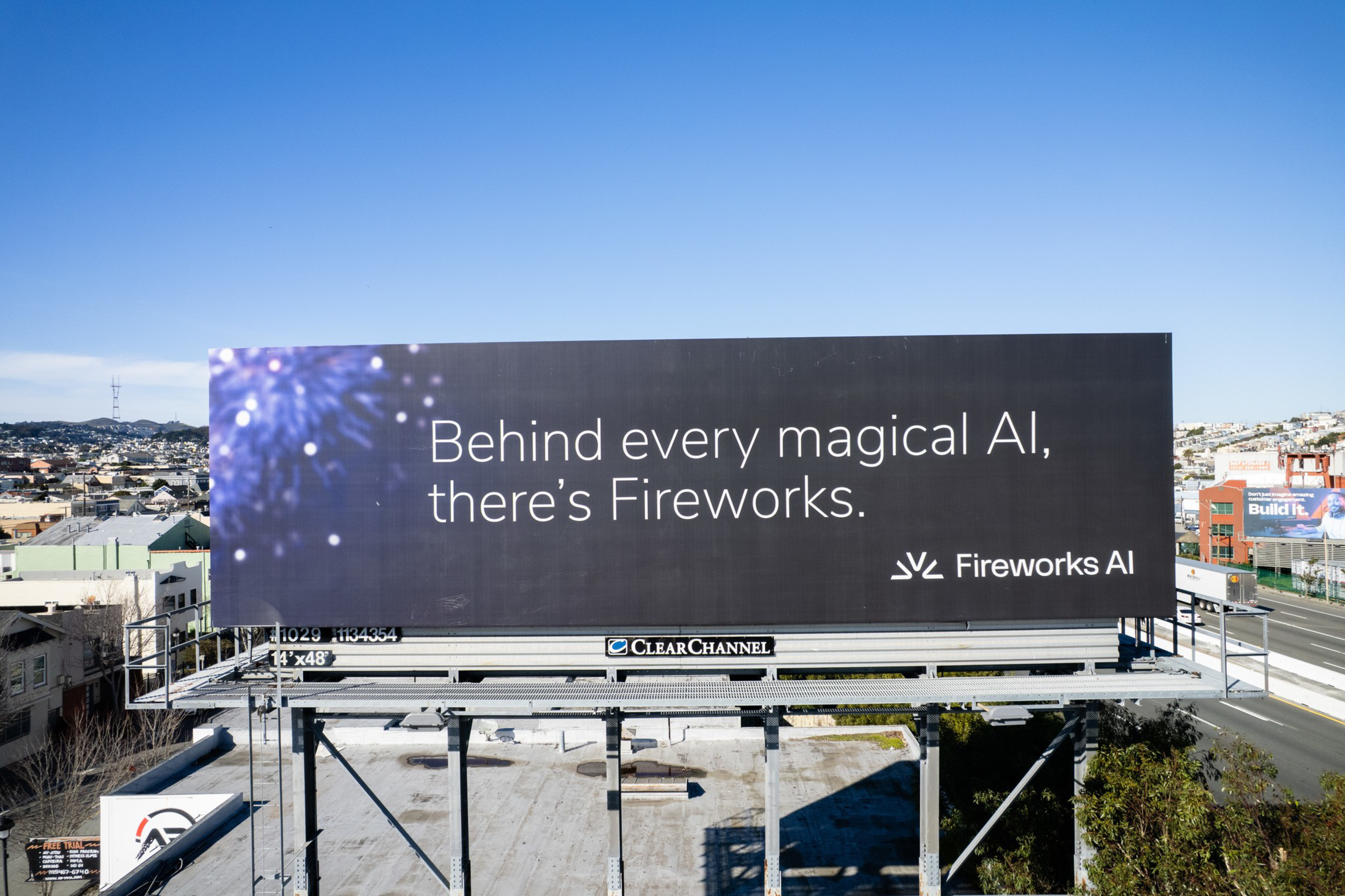 Behind every magical AI, there’s Fireworks, reads a billboard advertisement for Fireworks AI with a dark background and a small burst of fireworks on the left.