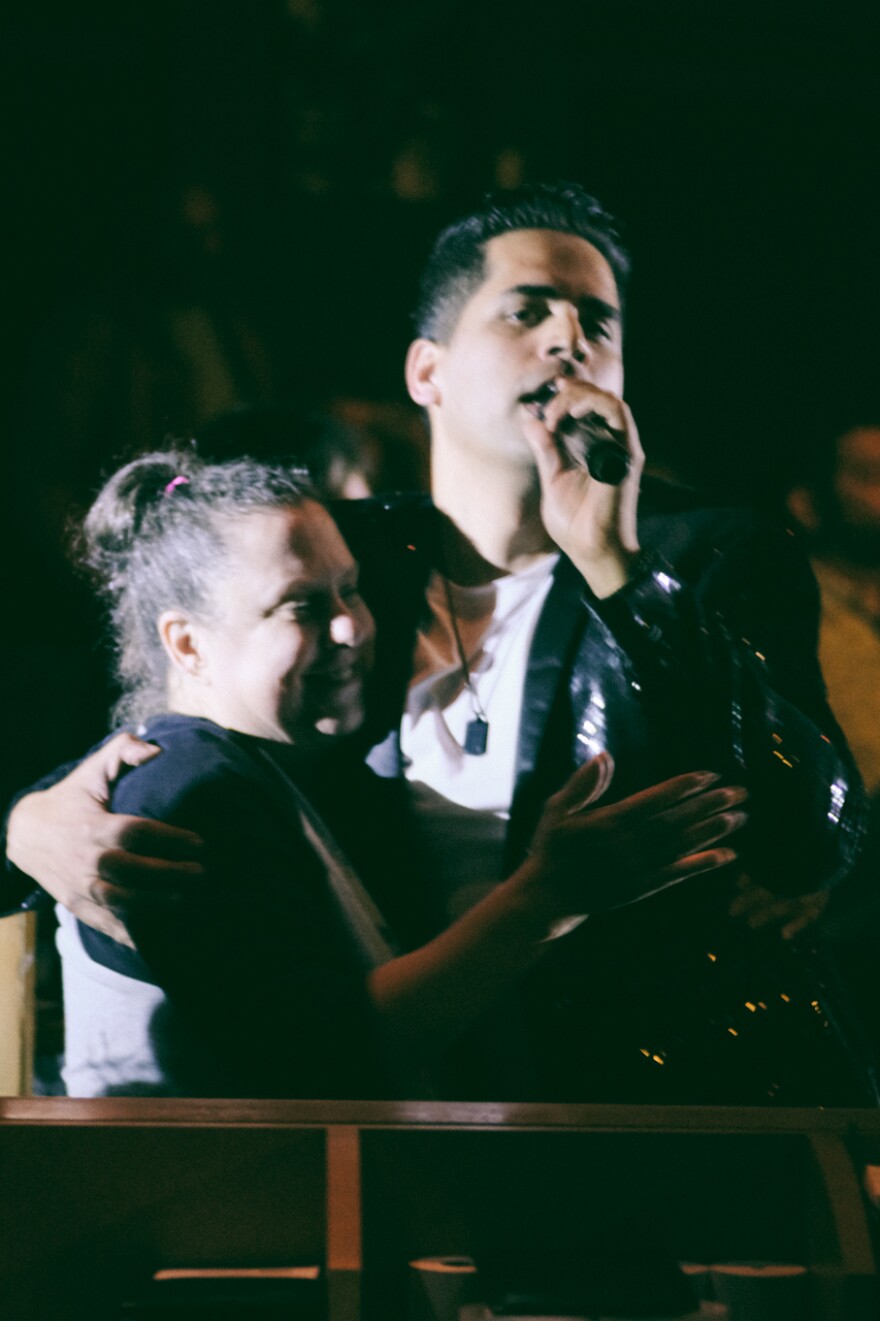 Lead vocalist, Jordan John, giving a hug to Kim Lafond during Tower of Power's performance at Yoshi's