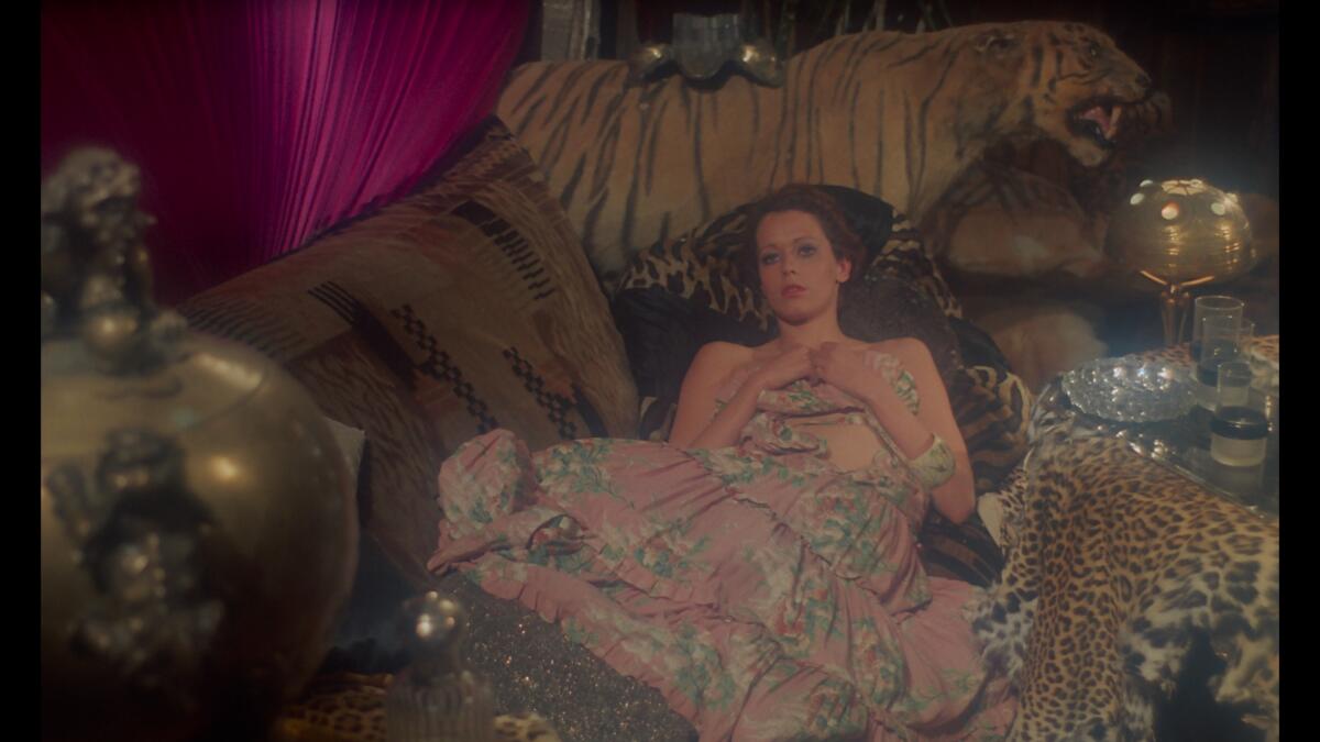 A woman leans back in a bed.