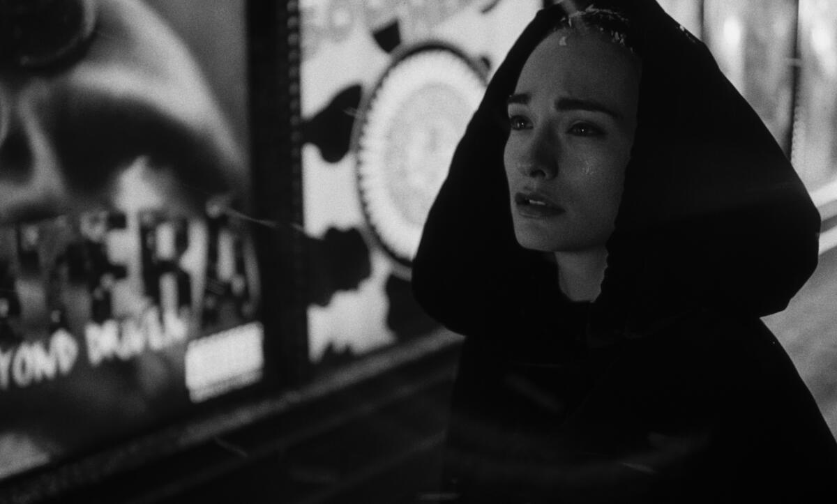 A woman in a cloak beguiles.